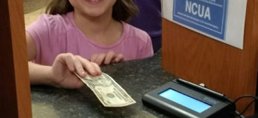 Brooklyn happily handing her savings over to a teller